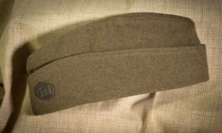 Overseas Hat — This hat was issued to American soldiers after they arrived in France. It was designed to fold and store easily in a pocket when a soldier needed to put on a helmet or gas mask. — Courtesy of Bob Ford