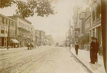 Main Street ca. 1907, looking west. The Hotel Coatesville is the large building with a second-story porch on the left of the photo. The clock tower of the new National Bank of Coatesville building appears in the right middle distance.